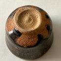 Black Karatsu sake cup showing textured base with kiln ash and moist black glaze craftsmanship by Kimiyuki.