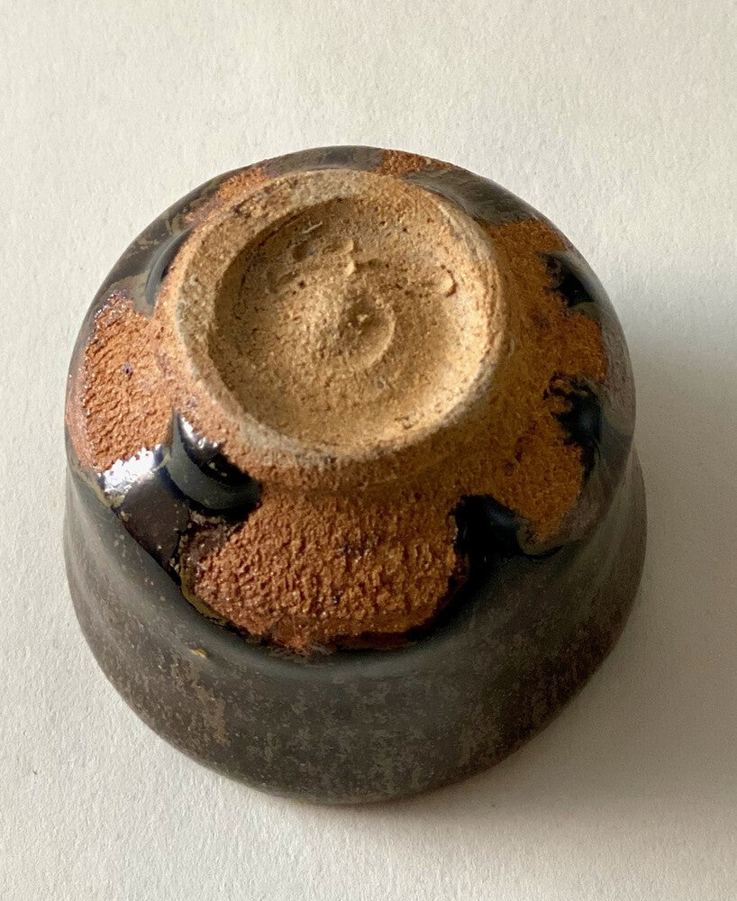 Black Karatsu sake cup showing textured base with kiln ash and moist black glaze craftsmanship by Kimiyuki.