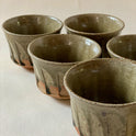 Blue Karatsu teacup set with deep green glaze and black iron dots on Karatsu ware clay surface.