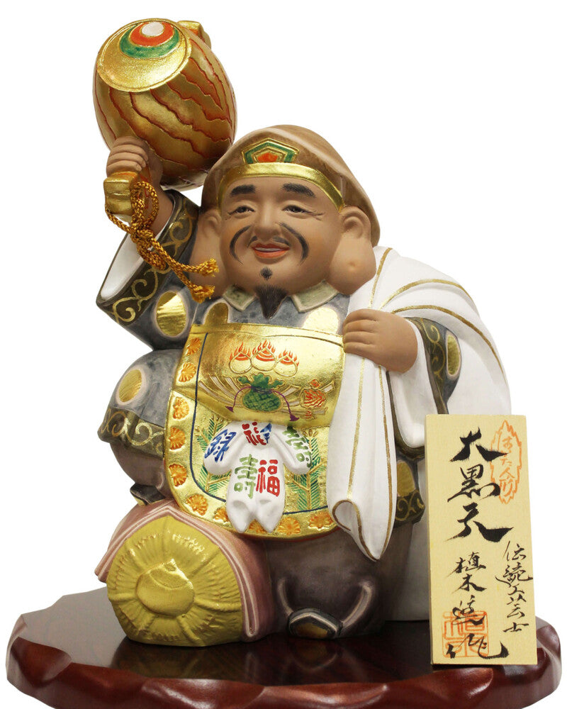 Daikokuten Hakata Doll by Susumu Ueki, 25cm tall, featuring gold and white traditional attire on wooden base.