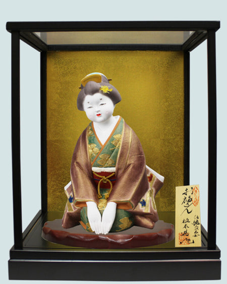 Hakata Doll Good Fortune featuring traditional Ofuku-san figure in glass case with nameplate and intricate kimono details.
